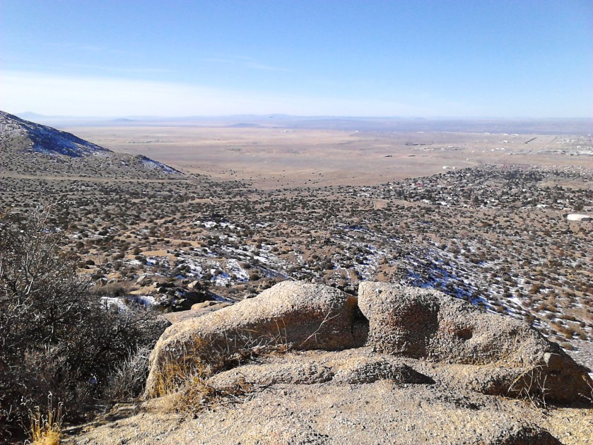 Albuquerque airport landing strip visible in distance at far right.  A plane is landing, but only a tiny dot in the photo.